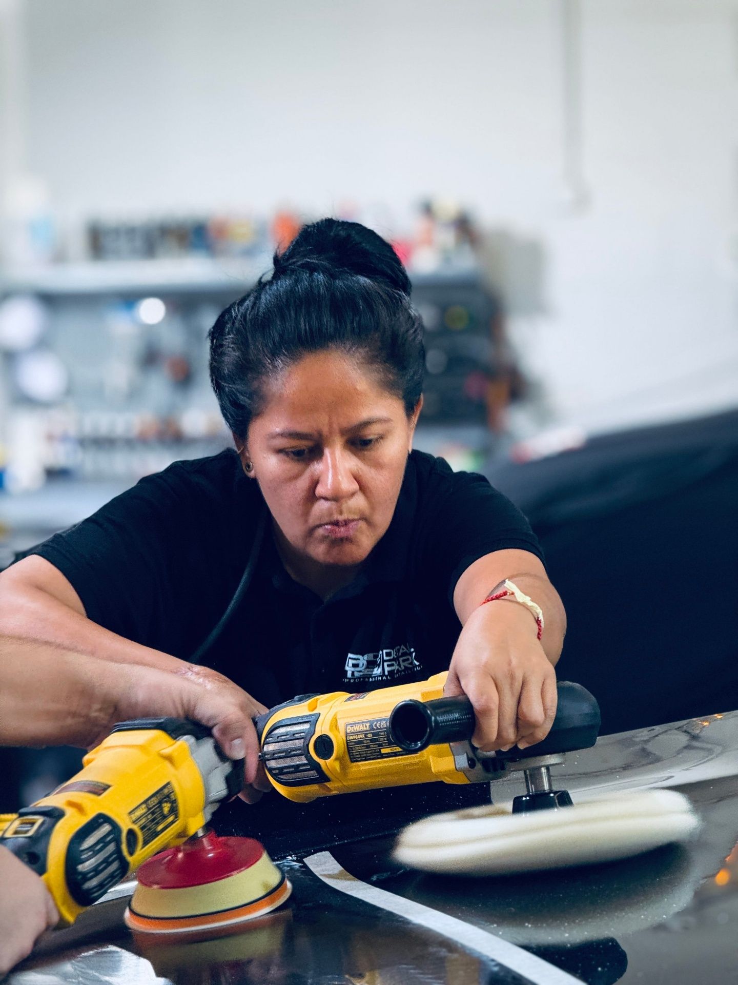 Alumna trabajando con doble pulidora DeWalt en sesión práctica avanzada de corrección de pintura