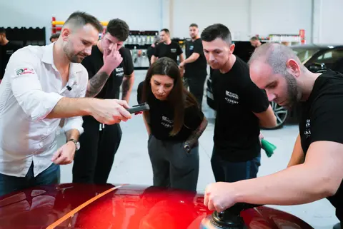 Grupo de alumnos alrededor de un coche rojo durante la Jornada Zero