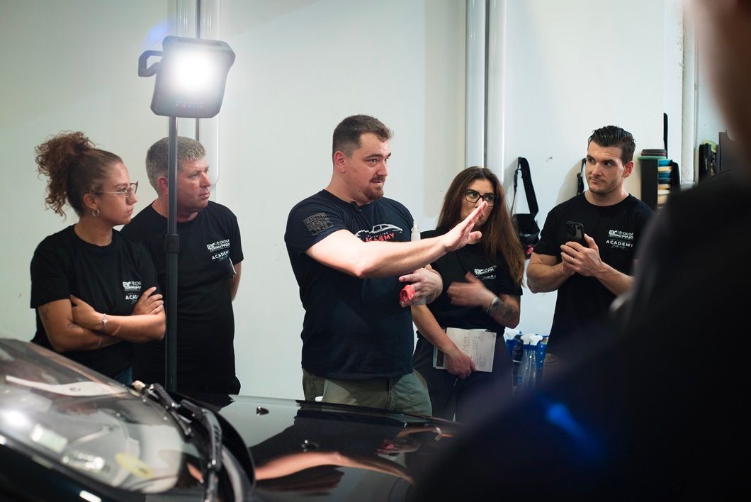 Instructor Leandro explicando técnicas de detailing a grupo de alumnos en instalaciones de Detail Park